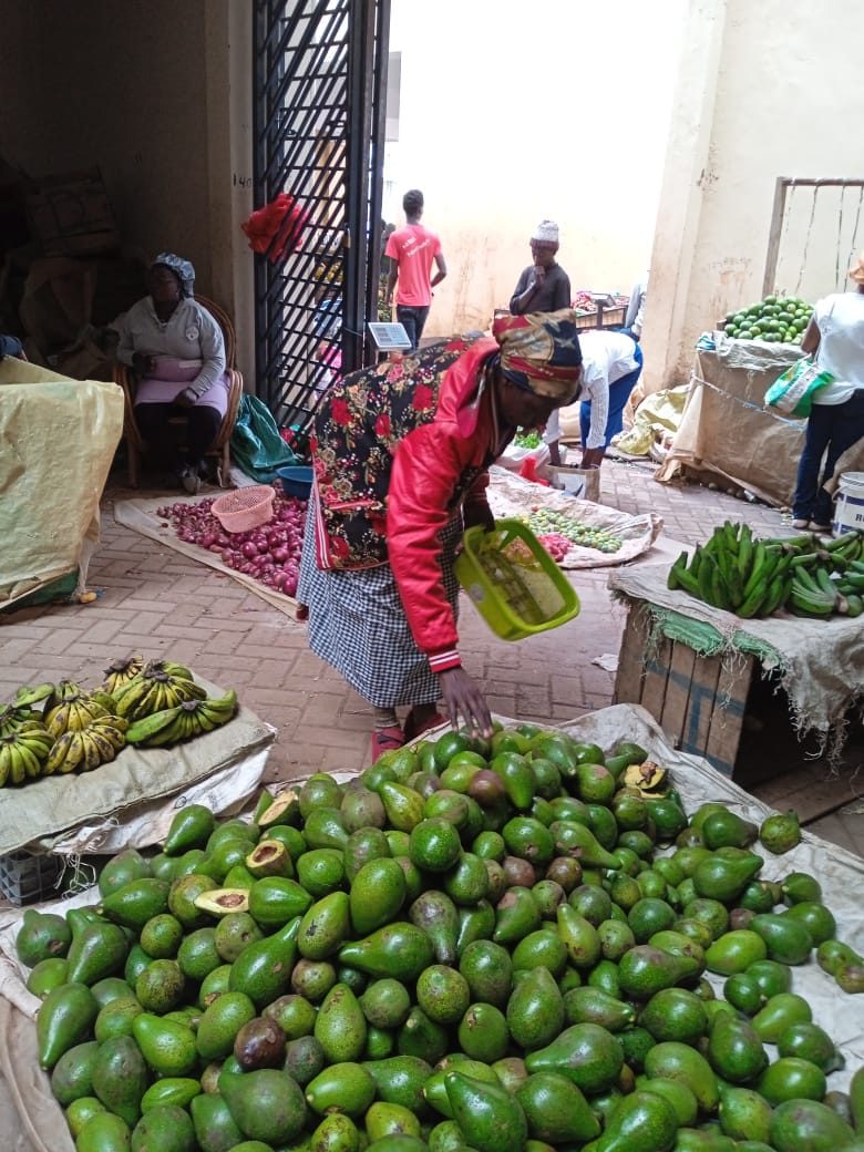Trader sorting avocados at a Kenyan market